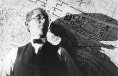 Le Corbusier, hacia 1925, fotografiado delante de una imagen del Plan Voisin para París. Fondation Le Corbusier, París.